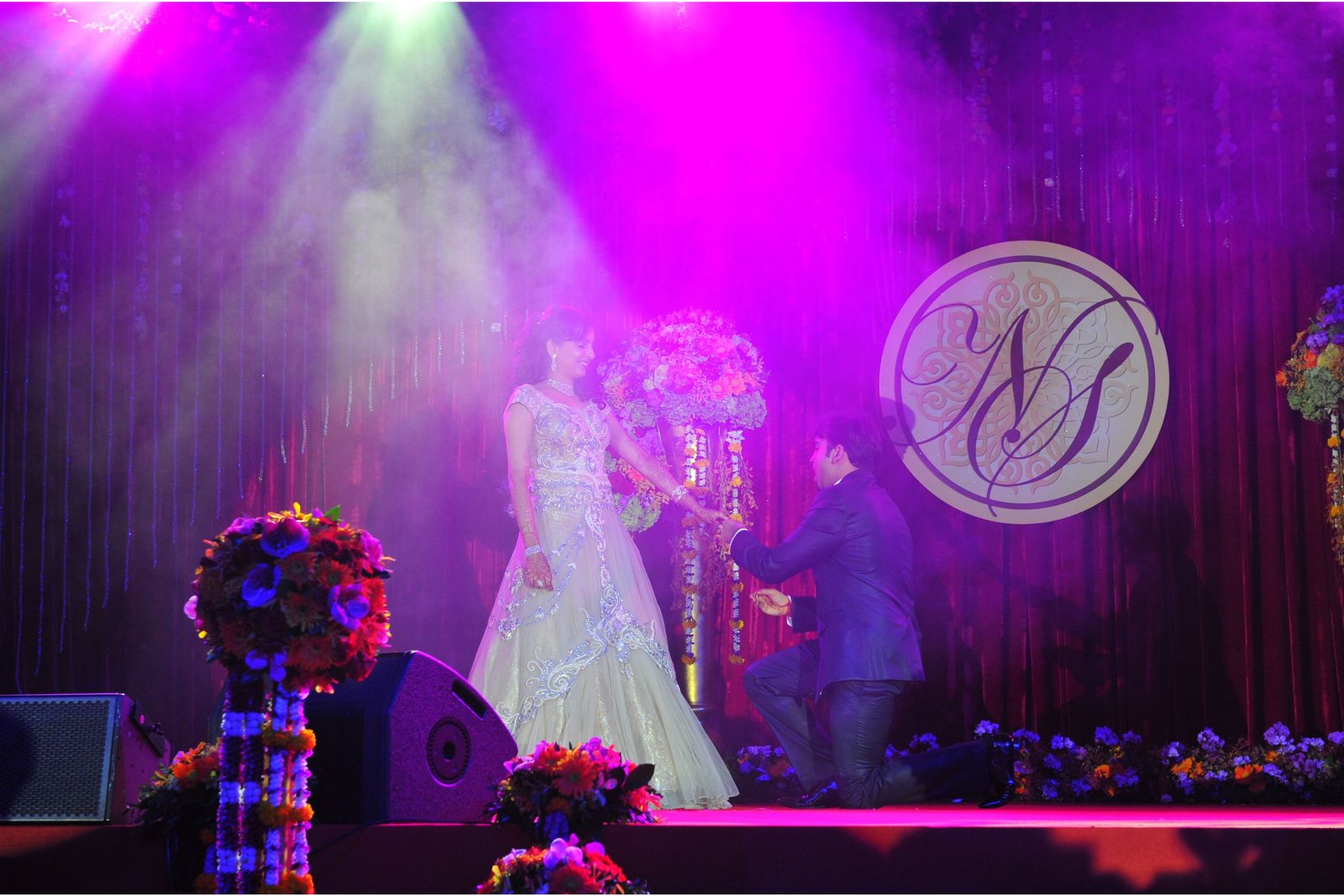 Men lighting ceremonial lamp at event with ITT banner in background